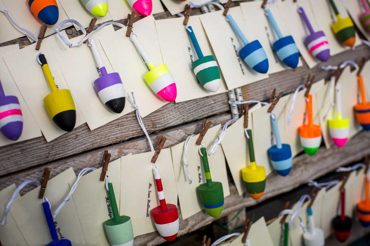 Wooden lobster buoys create a whimsical solution for place card settings at this Maine beachfront wedding. www.churchillevents.com Photo c/o Emilie Inc http://emilieinc.com